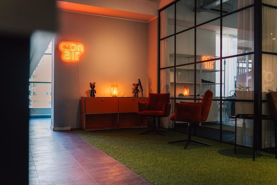 Lounge-Ecke im Büro von grynia consulting mit Leuchtschrift