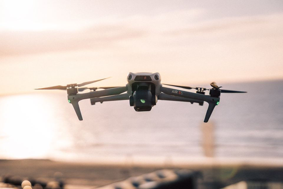 Drohne im Flug vor dem Meer im Abendlicht