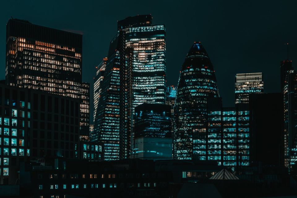 Skyline der City of London bei Nacht mit erleuchteten Bürotürmen