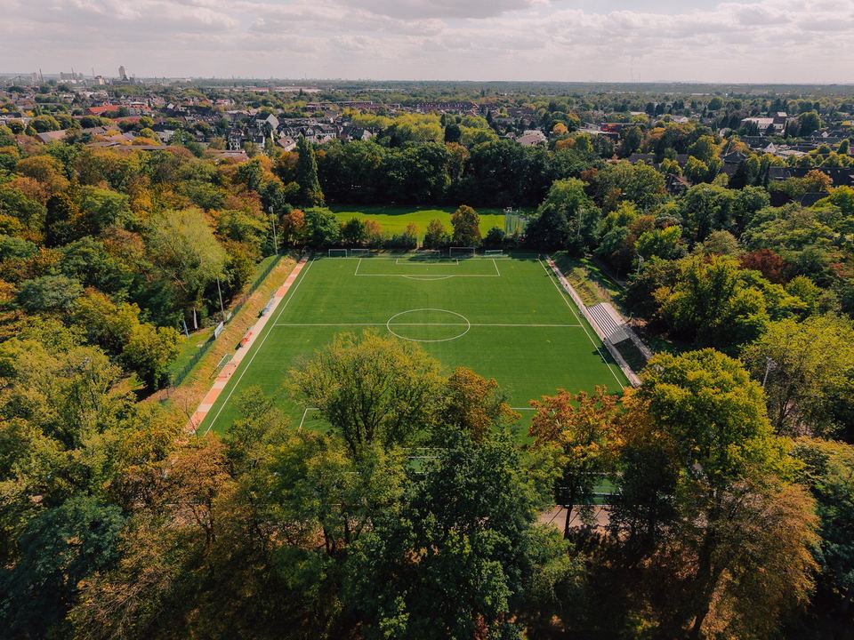 Luftbild: fertiger Sportplatz des Covestro Sportparks in Krefeld zwischen Bäumen