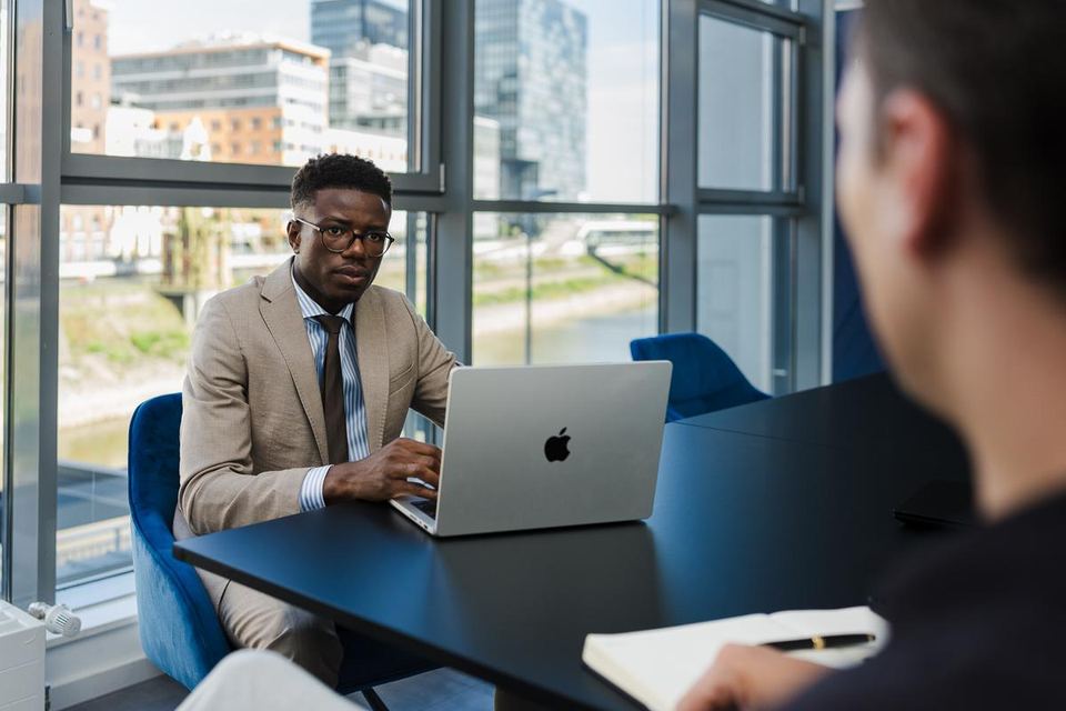 Junger Berater mit Laptop am Fenster bei grynia consulting